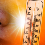 Ein Thermometer, das eine extrem hohe Temperatur anzeigt, neben einer stark schwitzenden Person. Symbolisch für die Belastung durch die Hitzewelle im Friseursalon.
