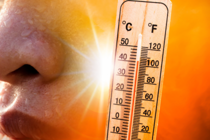Ein Thermometer, das eine extrem hohe Temperatur anzeigt, neben einer stark schwitzenden Person. Symbolisch für die Belastung durch die Hitzewelle im Friseursalon.